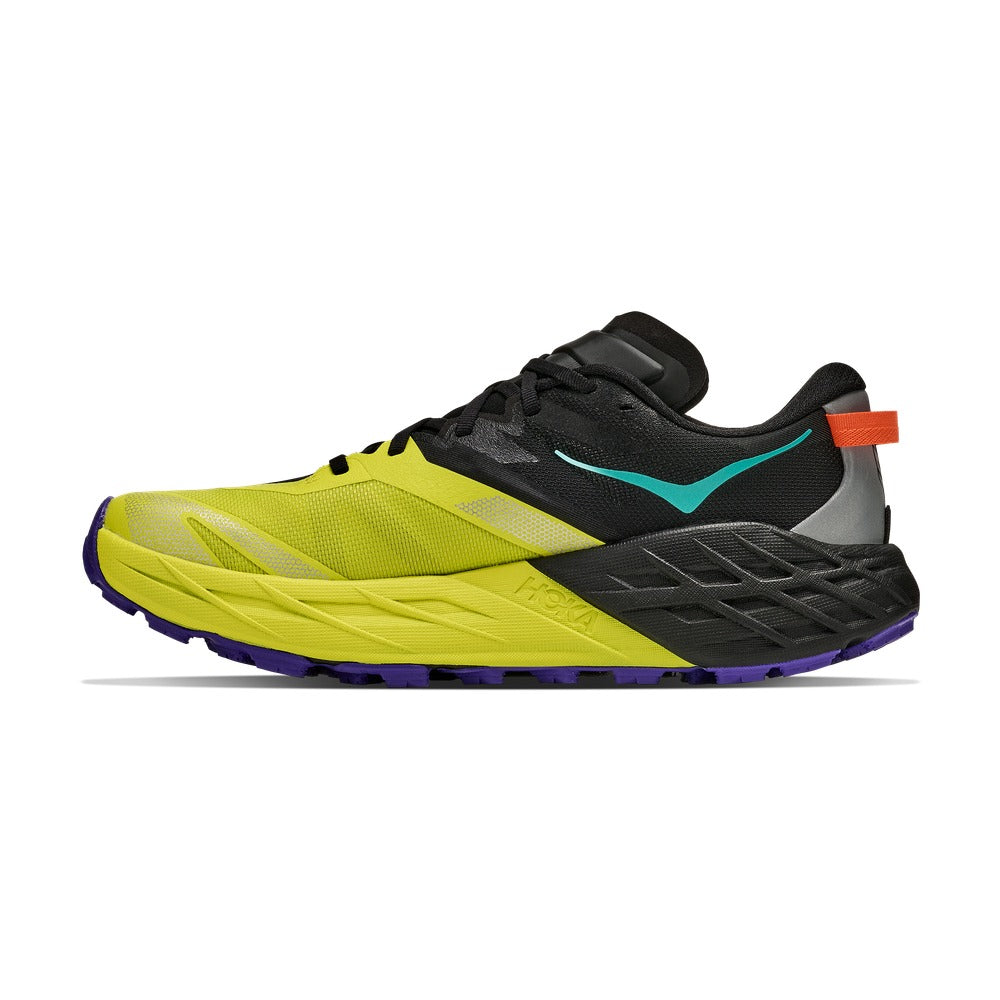 Vista lateral interior de la zapatilla trail Hoka Speedgoat 7 negro y amarillo con logo Hoka en el talón