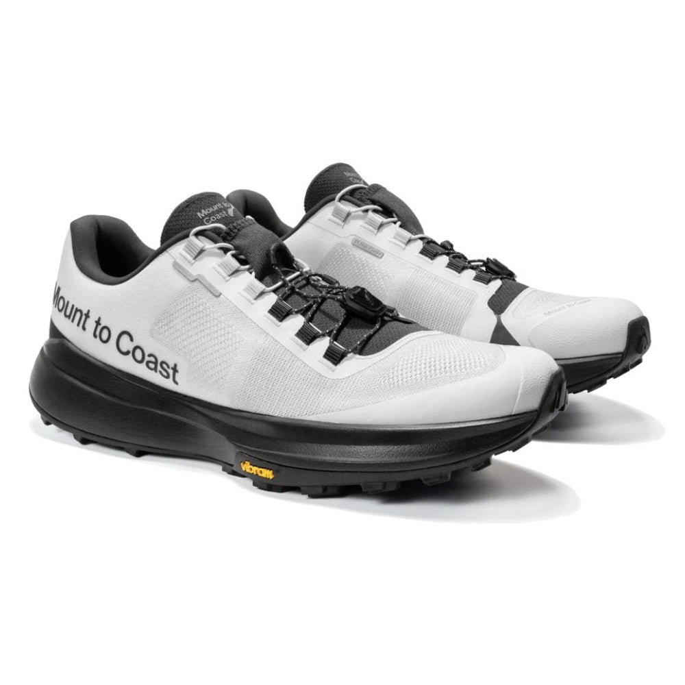 Par de zapatillas de trail running Mount to Coast T1 gris y negro, vista frontal en ángulo