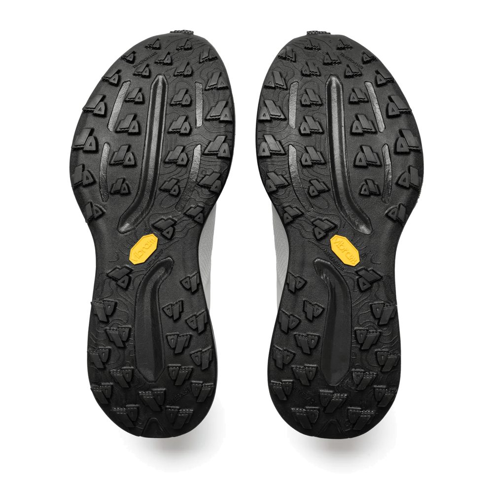 Suela Vibram Megagrip con tacos de 4 mm de la Mount to Coast T1 gris y negro, vista inferior del par