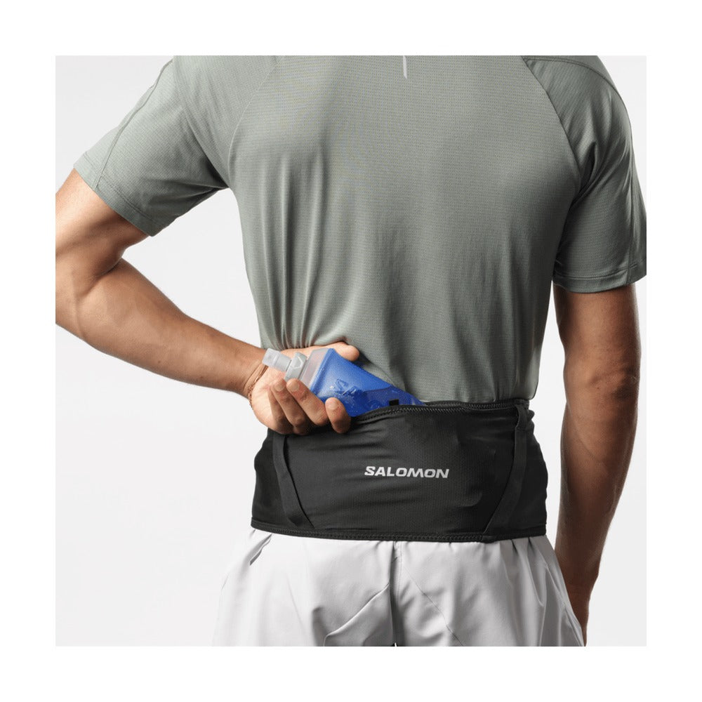 Corredor sacando un soft flask del bolsillo trasero del cinturón Salomon High Pulse Belt negro