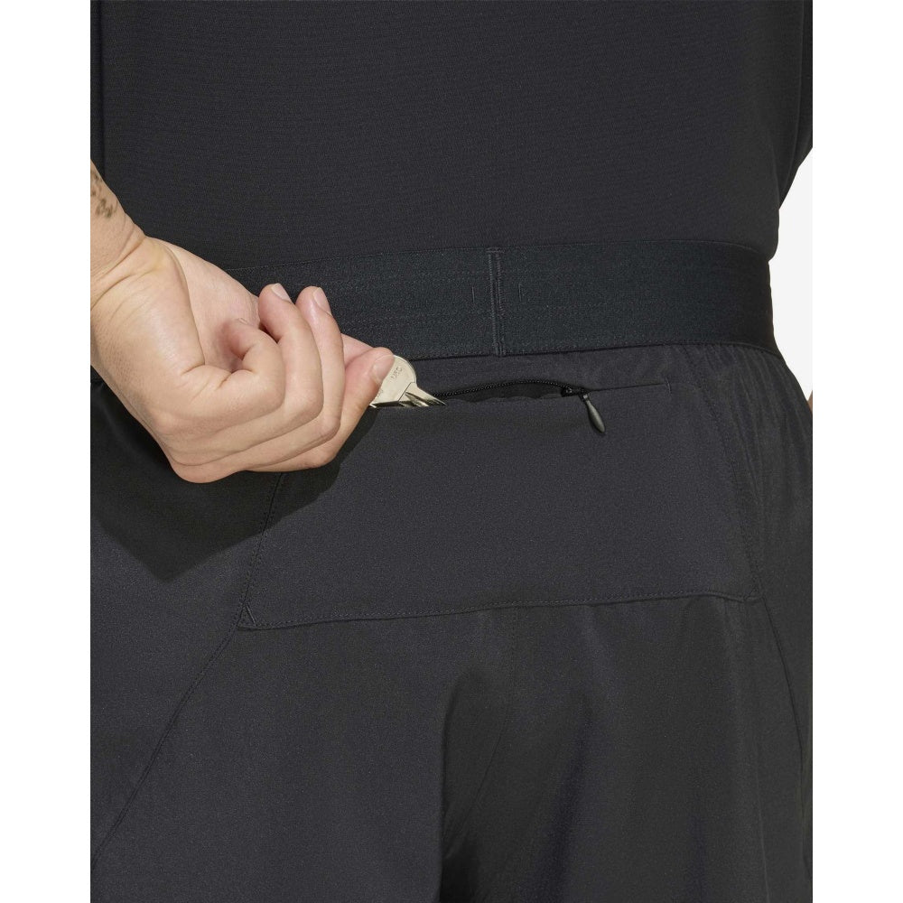 Detalle del bolsillo trasero con cremallera del short de running Adidas adi365 Running Essentials 5 pulgadas negro, con una llave guardada
